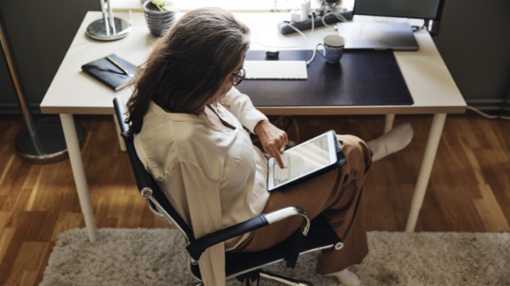 En kvinde med en arm sidder med en IPad