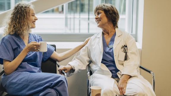 Læge og sygeplejerske drikker kaffe og snakker