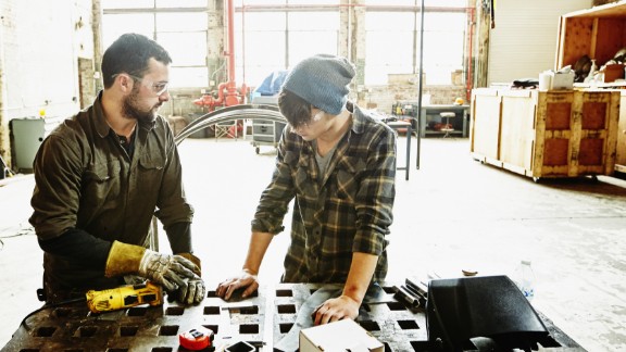 To mænd samarbejder på værksted