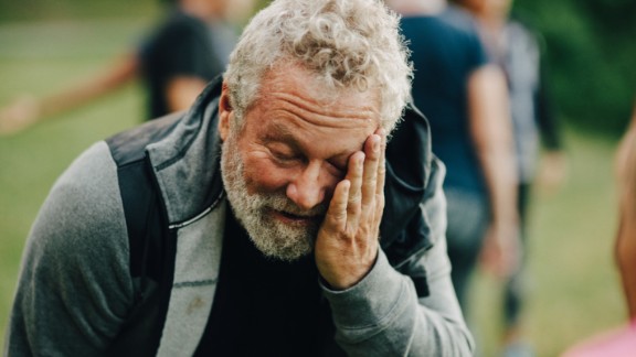 Mand sveder efter løbetur med hånd på hovedet