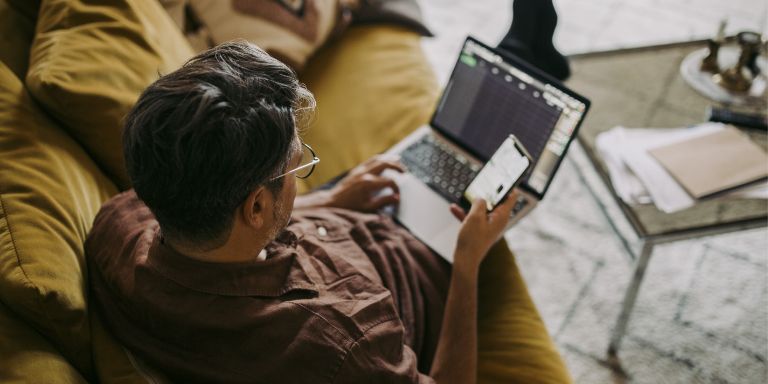 Mand_computer_og_mobil_i_sofa_content-header_768x384